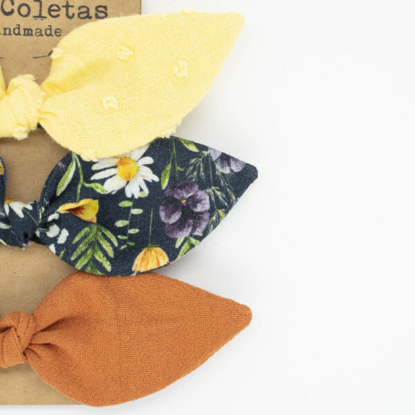 Detalle pack de tres coleteros con lazo amarillo negro flores y naranja rústico